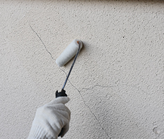 ひび割れに沿って幅300mm程度で塗布する様子